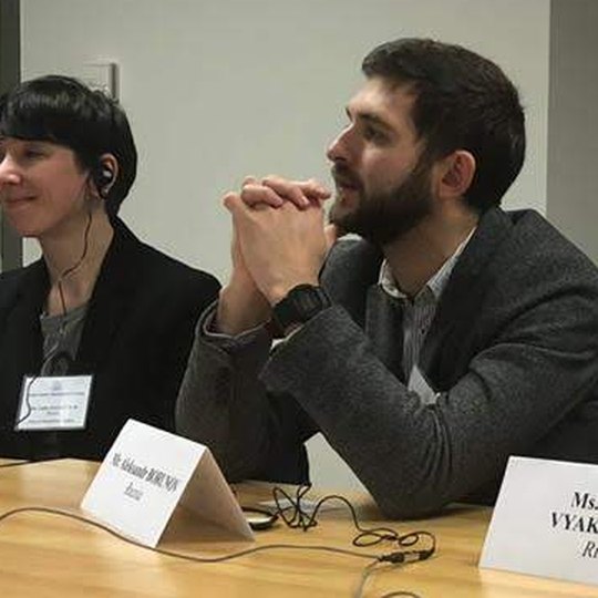 Alex at a programme meeting in Washington, behind a name card reading Mr. Aleksandr Borunov, Russia